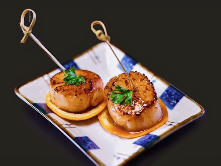 Two seared Hokkaido scallops on crostini at a San Francisco restaurant, the kind of standout dish that earns five-star Yelp and Google reviews